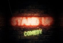 A neon sign on a wall that reads "stand up comedy"