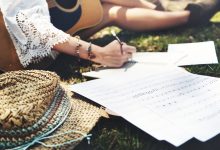 A girl with a guitar writing a song